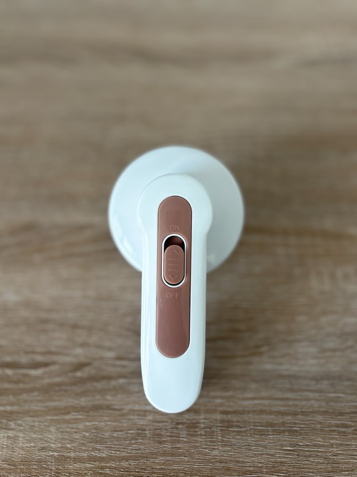 CocoonRevive Electric Lint Remover - back view showing rose gold ON/OFF switch